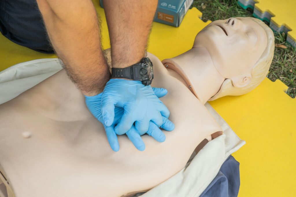 Home Close-up of hands performing CPR on a manikin for first aid training.